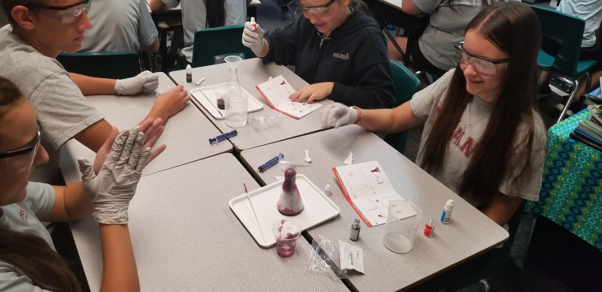 Student watches pink foam spill out of reaction vessel